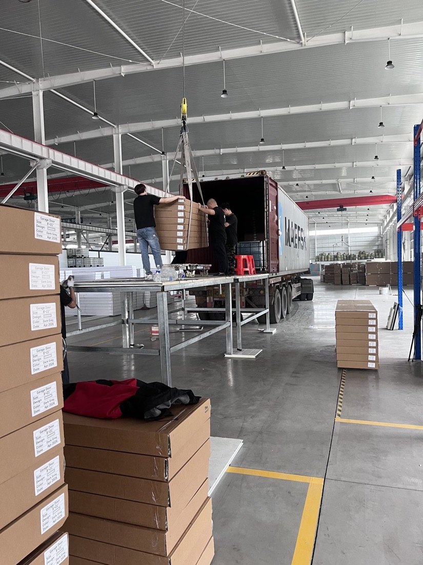Garage door panel cartons at container loading station